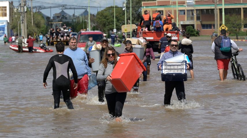 Pessoas que tiveram suas casas inundadas tentam salvar alguns pertences, em Bahia Blanca, na Argentina (Foto: AFP)