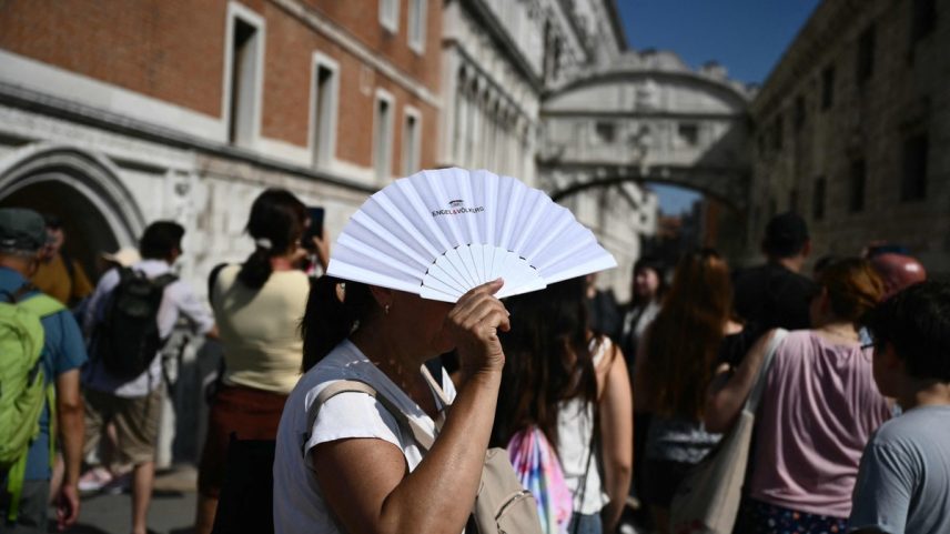 Uma mulher se protege do sol com um leque perto da Ponte dos Suspiros, em Veneza (Foto: Marco Bertorello / AFP)
