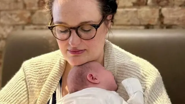 Charlie Beattie segura seu bebê de nove semanas nos braços depois de muitos anos de abortos espontâneos (Foto: Charlie Beattie)