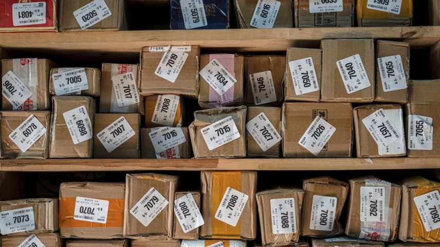 Pacotes em um centro de triagem de bairro em Pequim, China: remessas para os EUA recuam 40% em maio, mesmo em meio à trégua da tarifação dos EUA (Foto: Na Bian/Bloomberg)