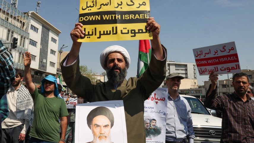 Manifestante iraniano com foto do aiatolá Ruhollah Khomeini durante protesto contra os ataques israelenses contra o Irã (Foto: Atta KENARE / AFP)