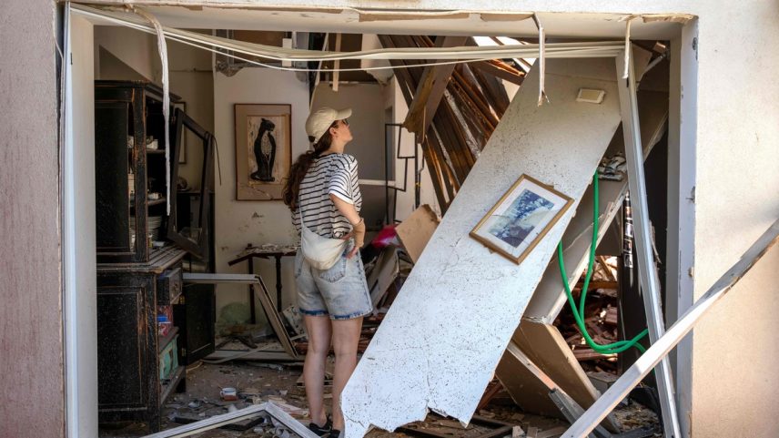 Moradora observa danos à casa após ataques do Irã a bairro de Tel Aviv (Foto: MAYA LEVIN / AFP)