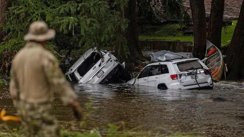 Veículos estão submersos enquanto um trabalhador de busca e resgate procura entre os destroços por sobreviventes ou restos de pessoas levadas pela enchente repentina no Texas. (Foto: Getty Images)