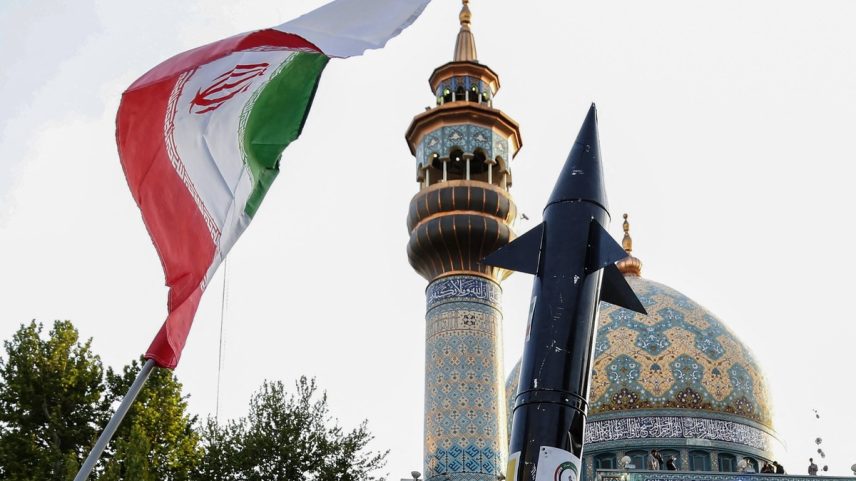 Iranianos levantam uma bandeira e a simulação de um míssil (Foto: AFP)