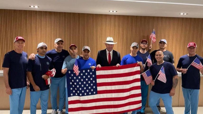 Dahud Hanid Ortiz, segundo da direita (com gorra), junto aos outros nove liberados, posando na sexta-feira com a bandeira americana e ao lado do encarregado de negócios da Embaixada dos Estados Unidos na Venezuela, John McNamara (com chapéu), em uma imagem divulgada na conta de X dessa missão diplomática. (Foto: EFE)
