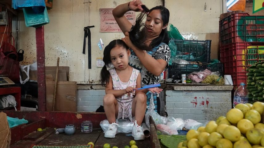Uma mãe penteia sua filha no Mercado de la Merced da Cidade do México. (Foto: Graciela López Herrera/Cuartoscuro)