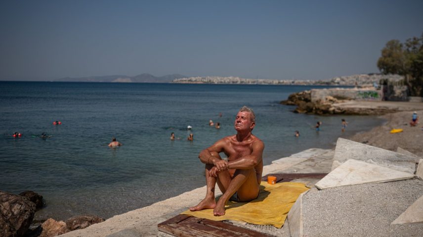 Homem curte praia em Atenas, na Grécia; regiões registraram 45,8°C durante onda de calor que atinge o país (Foto: Angelos Tzortznis/AFP)