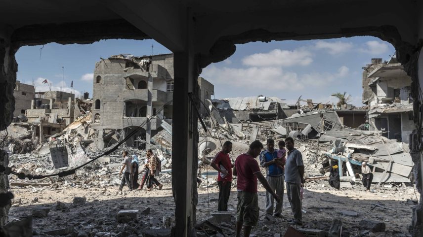 Palestinos ao lado de casas destruídas por bombardeios israelenses em Beit Hanoun, no norte da Faixa de Gaza, em 26 de julho de 2014. (Foto: Sergey Ponomarev / The New York Times)