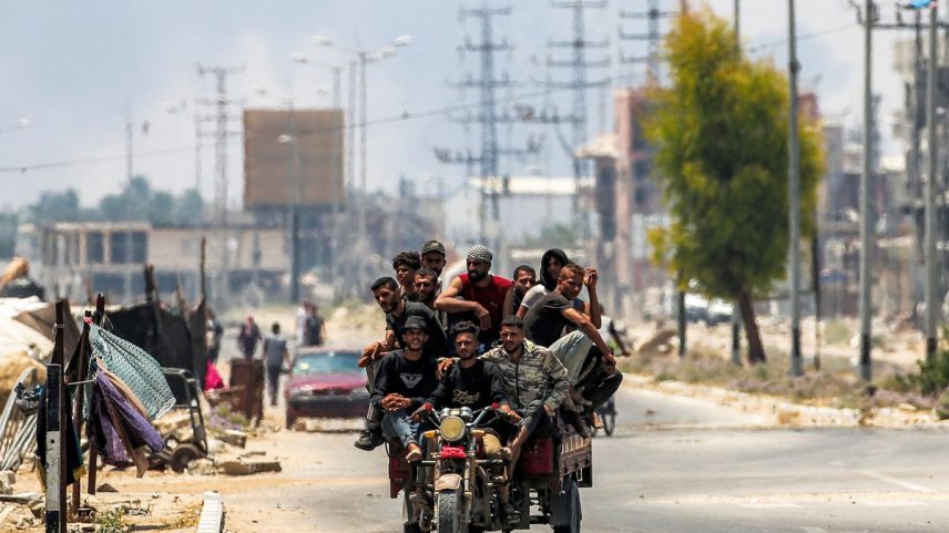 Homens seguem em um triciclo pela estrada Salah al-Din, em Deir el-Balah, no centro da Faixa de Gaza, em 21 de julho de 2025, após ordens de evacuação do Exército de Israel (Foto: Eyad Baba / AFP)