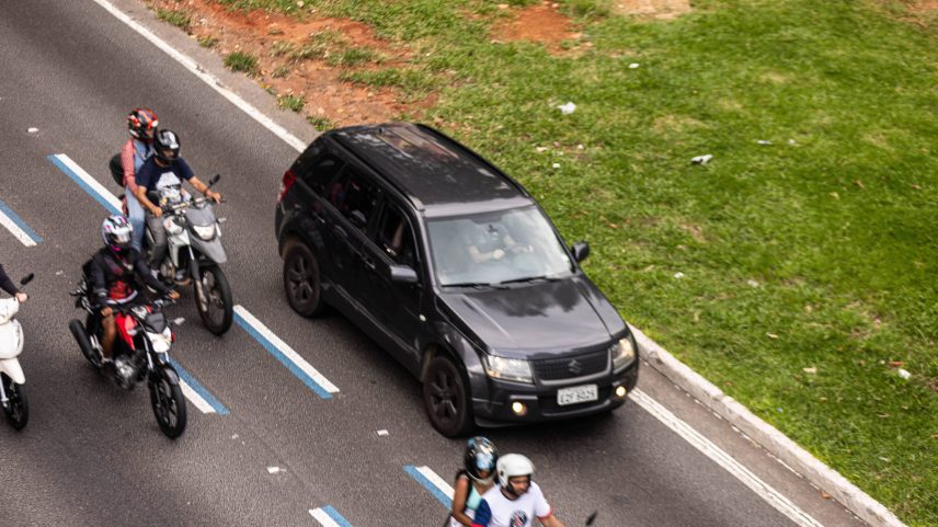 Motociclista ultrapassa outras motos fora da faixa azul na avenida 23 de Maio, em São Paulo; modelo em testes na capital paulista é replicado em outras cidades (Foto: Pedro Affonso - 10.fev.25/Folhapress)