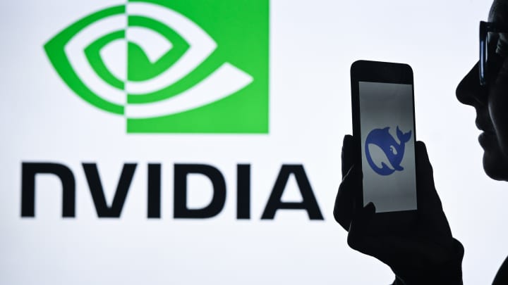 Uma mulher segura um celular com o logo da DeepSeek, com o logo da Nvidia exibido ao fundo. (Foto: Nurphoto | Nurphoto | Getty Images)