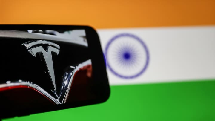 O logotipo da Tesla é exibido na tela de um celular em frente à bandeira indiana em Ancara, Turquia, em 28 de novembro de 2023. (Foto: Cem Genco | Anadolu | Getty Images)
