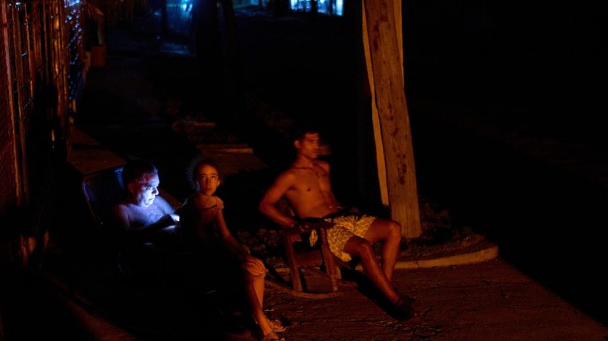 Cubanos sentam na rua durante um apagão em Havana (Foto: Ramon Espinosa/AP)