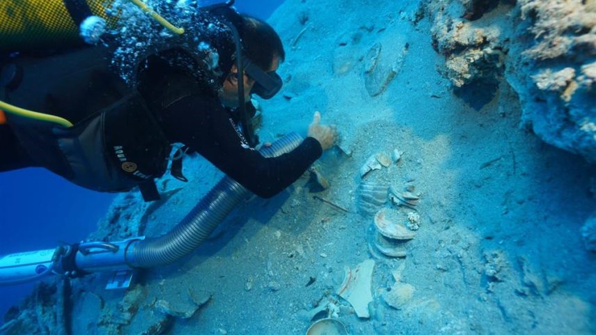 Um mergulhador cuidadosamente escova a areia de cerâmicas empilhadas encontradas em um naufrágio ao largo da costa da Turquia. (Foto: Ministério da Cultura e Turismo, Turquia)