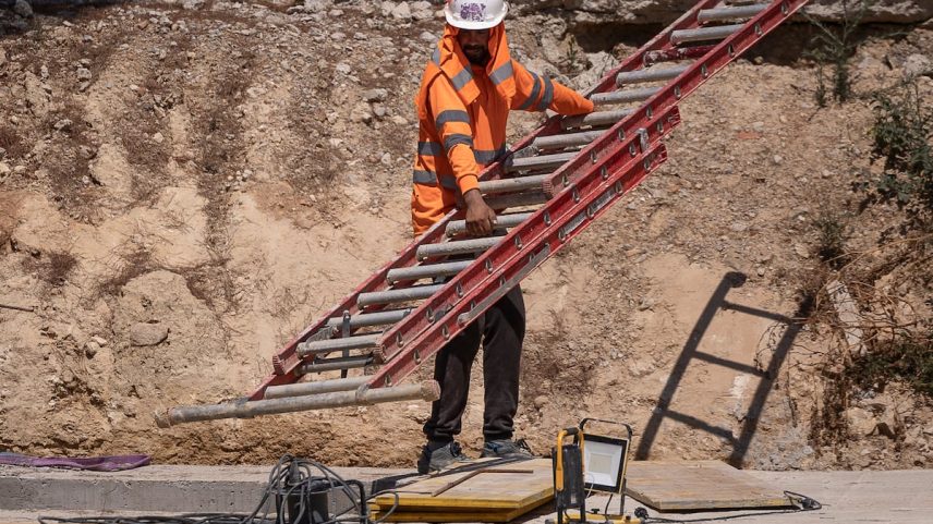 Um trabalhador da construção se protege do sol em uma obra do Eixample de Barcelona. (Foto: Albert Garcia)