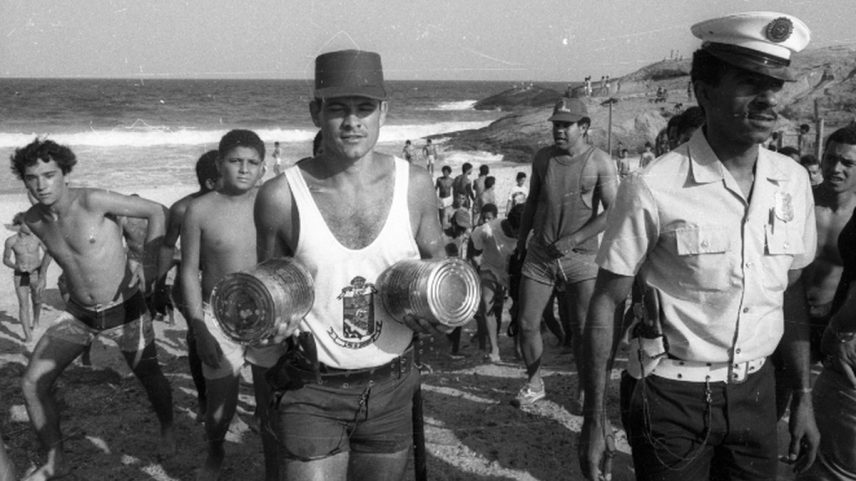 Policial com latas cheias de maconha saindo da praia de Ipanema (Foto: Lucio Marreiro/Agência O GLOBO)