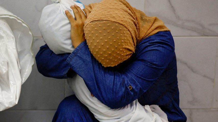 Inas Abu Maamar, 36, abraça o corpo da sobrinha de 5 anos, Saly, morta em bombardeio de Israel ao hospital Nasser, em Khan Younis, na Faixa de Gaza. (Foto: Mohammed Salem/Reuters)