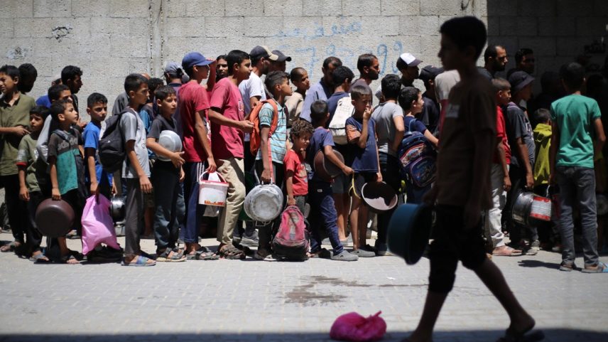 Civis se amontoam em busca de alimentos do lado de fora de centro de distribuição de ajuda no campo de refugiados de Nuseirat, na Faixa de Gaza (Foto: Eyad BABA / AFP)