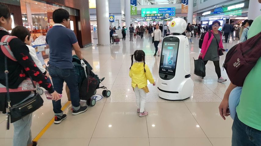 Um robô guia uma família no aeroporto de Seul. (Foto: Reprodução)