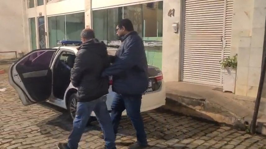 Suspeito preso é encaminhado para a viatura da Polícia Civil (Foto: Reprodução)