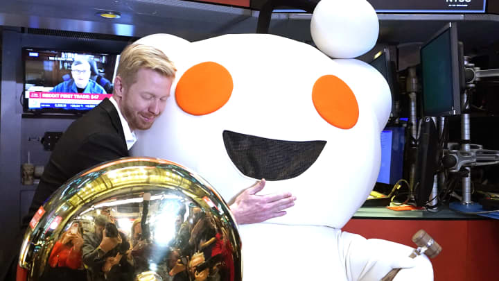 Steve Huffman, CEO do Reddit, abraça a mascote Snoo enquanto o Reddit começa a ser negociado na Bolsa de Valores de Nova York em 21 de março de 2024. (Foto: Timothy A. Clary | AFP | Getty Images)