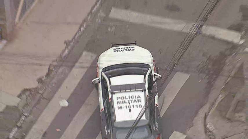 Viatura com agente andando com arma para fora em Paraisópolis. (Foto: Reprodução/ TV Globo)