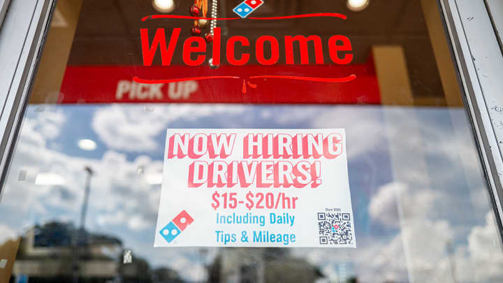 Uma placa de contratação é exibida na janela de uma pizzaria Domino's em 25 de junho de 2025 em Austin, Texas. (Foto: Brandon Bell | Getty Images)