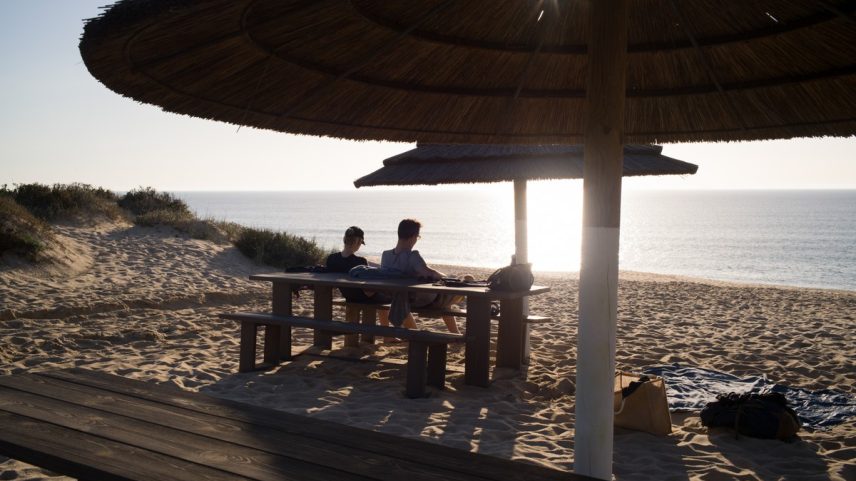 Visitantes relaxam em uma praia próxima a Comporta, em Portugal (Foto: Goncalo Fonseca/Bloomberg)