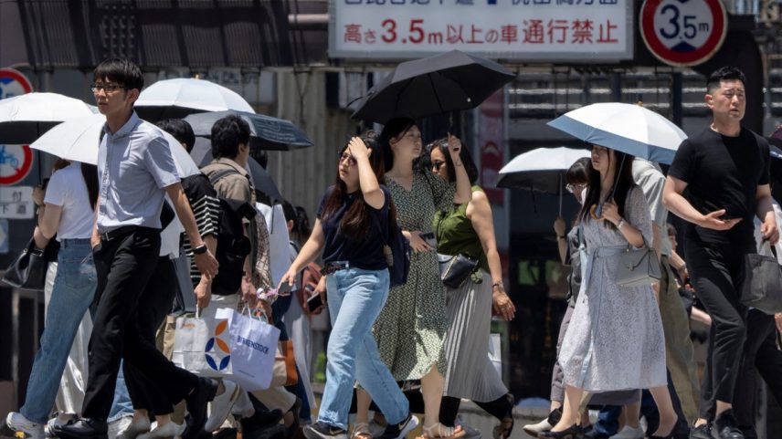 Pessoas caminham por uma rua em um dia quente em Tóquio (Foto: Kazuhiro NOGI / AFP)