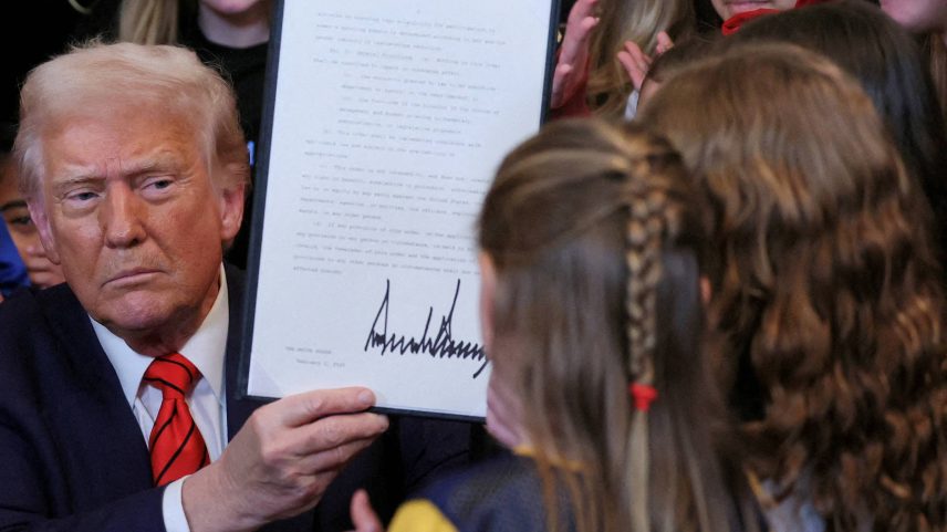 O presidente dos Estados Unidos, Donald Trump, exibe o decreto contra mulheres trans no esporte feminino, assinado em fevereiro (Foto: Leah Millis - 5.fev.25/Reuters)