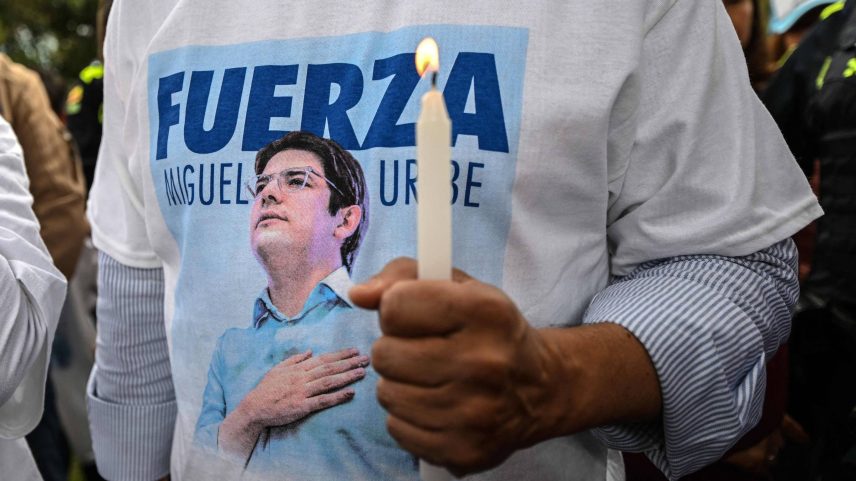 Homem vestindo uma camiseta com a imagem do pré-candidato à Presidência da Colômbia Miguel Uribe segura vela durante missa em Bogotá pela saúde do político (Foto: Luís Acosta/AFP)