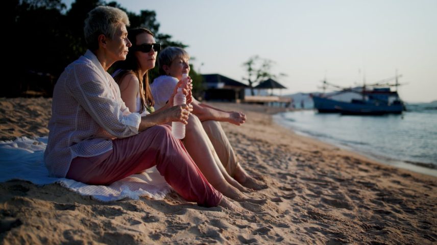 Três mulheres desfrutam de um rato de tempo livre em uma praia. (Foto: onuma Inthapong/Getty Images)