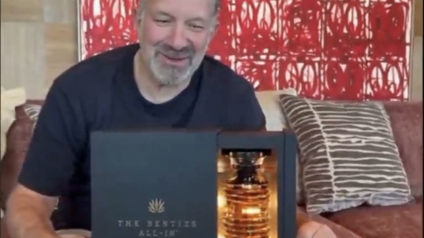 Howard Lutnick com sua nova garrafa de tequila—e o que parece ser uma pintura de Rashid Johnson. (Foto: Via X)