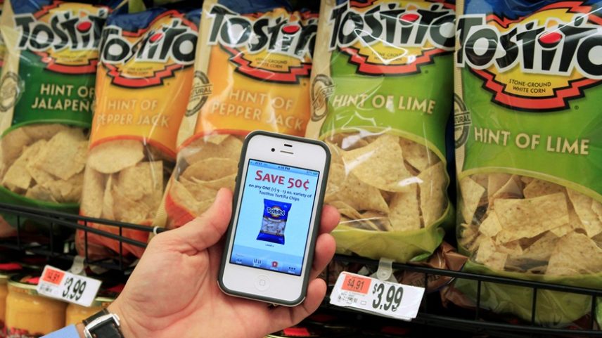 Um cliente com o aplicativo móvel Scan It! em seu iPhone mostra um cupom para salgadinhos Tostitos enquanto faz compras no supermercado Stop and Shop em Braintree, Massachusetts, 17 de outubro de 2011 (Foto: Reuters)