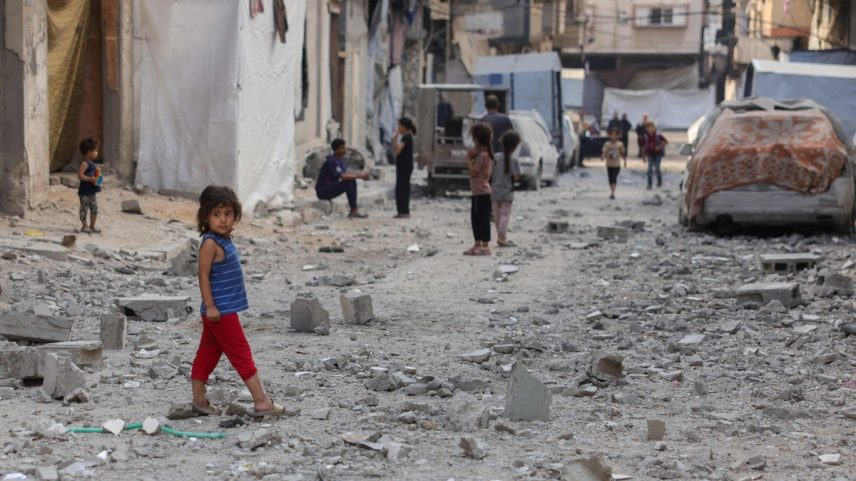 Crianças palestinas caminham em ruas cobertas por escombros de edifício atingido por ataque israelense na cidade de Gaza (Foto: Bashar TALEB / AFP)