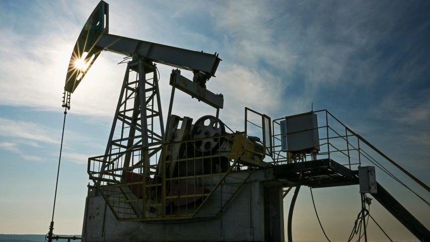 Uma bomba de petróleo em um campo de petróleo com o flare do sol visto através da cabeça da bomba (Foto: Maksim Bogodvid / Sputnik via AP)