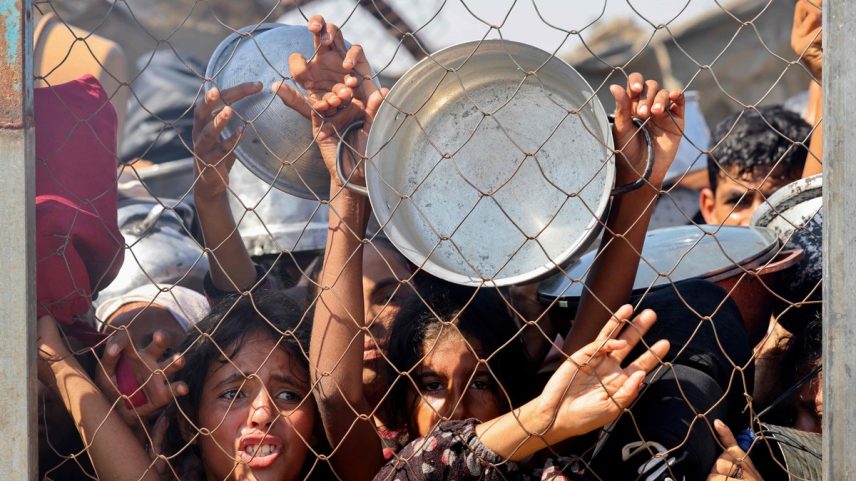 Crianças palestinas imploram por comida em área de ajuda humanitária próxima a Khan Younis, na Faixa de Gaza, em 22 de julho de 2025 (Foto: AFP)