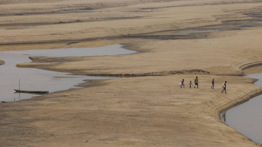 Moradores caminham pelo leito seco de um braço do rio Solimões próximo à comunidade indígena Porto Praia, no município de Tefé (AM) (Foto: Lalo de Almeida - 18.set.24/Folhapress)