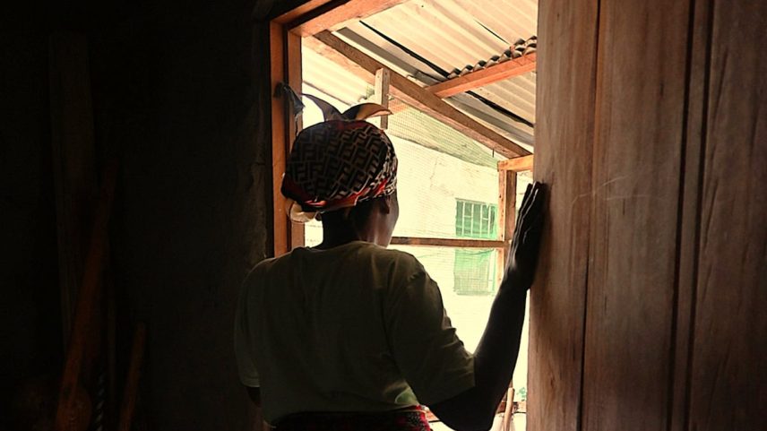 Evelyn (nome fictício) na porta de sua casa, em Monróvia, em maio de 2025 (Foto: Graziana Solano)