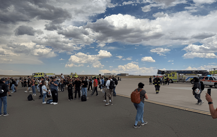 Passageiros se reúnem após evacuar um avião da American Airlines que pegou fogo, no Aeroporto Internacional de Denver, Denver, Colorado, EUA, em 26 de julho de 2025, nesta foto obtida nas redes sociais. (Foto: @highlymigratoryfishing via Instagram/via REUTERS)