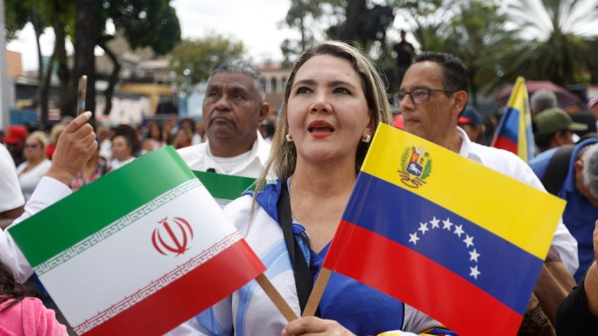 Uma mulher segura uma bandeira do Irã e da Venezuela durante uma marcha em Caracas em 25 de junho (Foto: Pedro Mattey/AFP)
