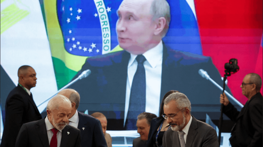 O presidente do Brasil, Luiz Inácio Lula da Silva, observa enquanto o presidente da Rússia, Vladimir Putin, aparece em uma tela ao fundo, durante a participação remota na reunião de abertura da Cúpula do BRICS, no Museu de Arte Moderna (MAM), no Rio de Janeiro, Brasil, 6 de julho de 2025. (Foto: REUTERS/Ricardo Moraes)
