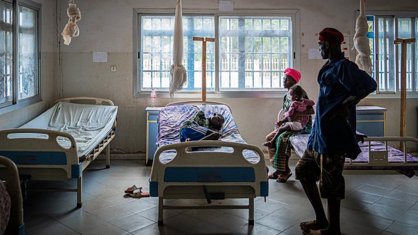 Mohamed Camara, de 10 anos, descansa em uma cama do Centro de Saúde de Tamita em junho de 2025. Le foram diagnosticada malária em meio a uma crise de saúde global por causa dos cortes de ajuda exterior dos EUA. (Foto: Marta Moreiras)