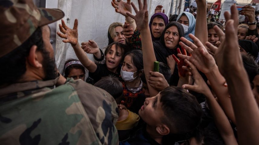 Oficial talibã distribui comida para refugiados afegãos em centro de recepção na fronteira: retorno em massa desafia autoridades (Foto: Jim Huylebroek/The New York Times)