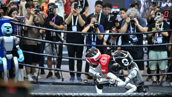 Robôs da Unitree Robotics mostram suas habilidades de kickboxing durante a Conferência Mundial de IA de 2025 (WAIC) e Reunião de Alto Nível sobre Governança Global de IA no Centro de Exposições e Convenções da Expo Mundial de Xangai em 27 de julho de 2025, na China. (Foto: Vcg | Visual China Group | Getty Images)