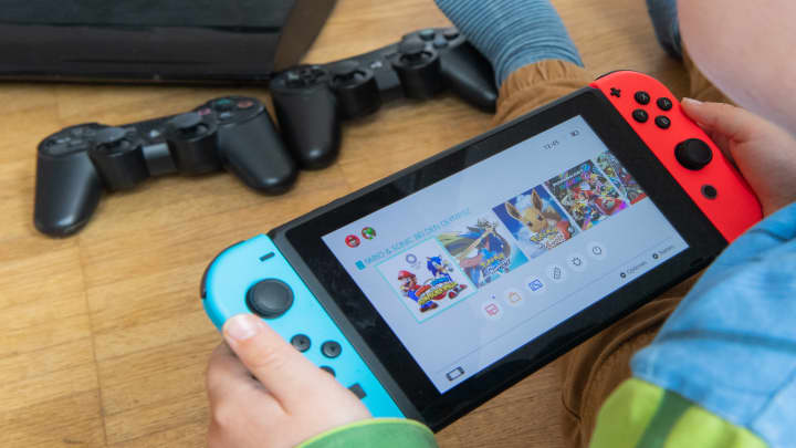 Uma criança brincando com um console de jogos Nintendo Switch. (Foto: Julian Stratenschulte | picture alliance via Getty Images)