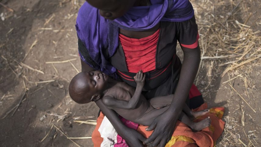 Mulher passando fome segura nos próprios braços filho desnutrido, no Sudão do Sul (Foto: AP)