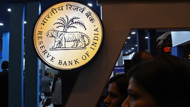 Mulheres (silhuetas) passam pelo logo do Banco Reserve Bank of India (RBI) exibido na feira Global Fintech Fest em Mumbai. (Foto: Sopa Images | Lightrocket | Getty Images)