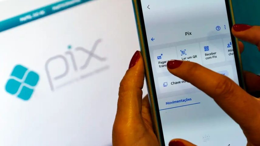Pessoa segurando celular na área Pix de aplicativo bancário (Foto: Bruno Peres/Agência Brasil)
