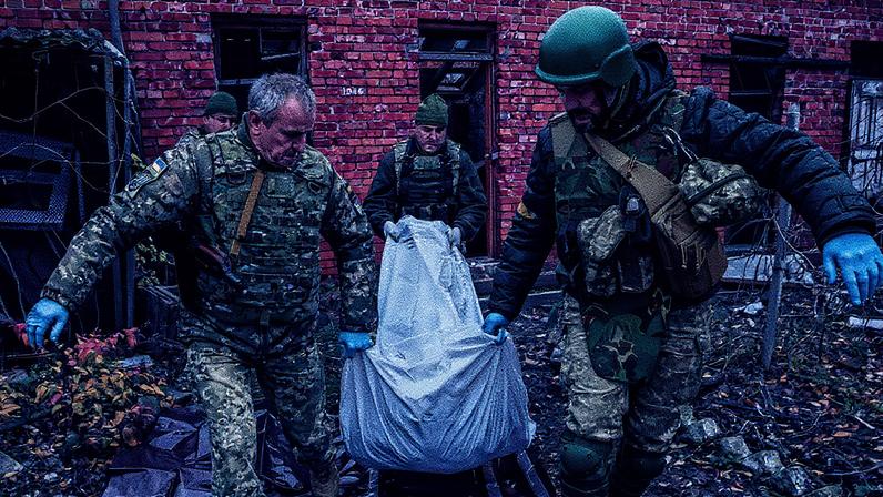 Soldados ucranianos removem o corpo de um soldado russo em uma área de conflito na Ucrânia (Foto: Reprodução)